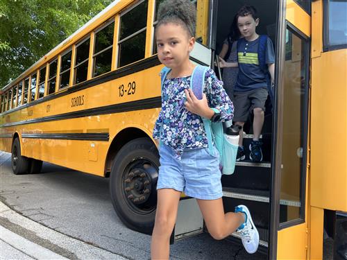 student hopping off bus